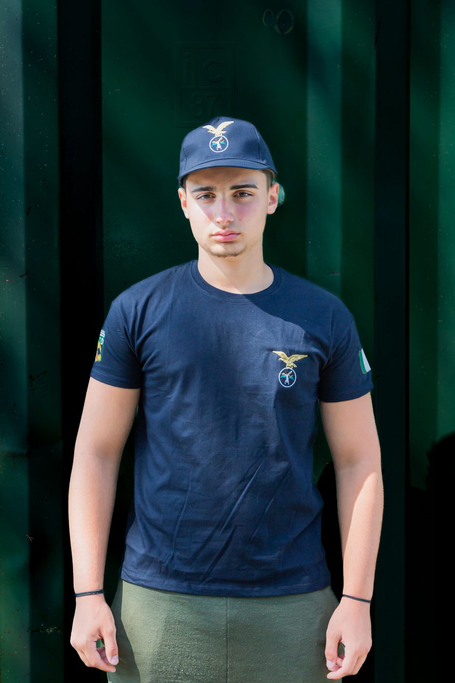 Ragazzo di fronte con maglietta blu del Campo Scuola e cappellino blu