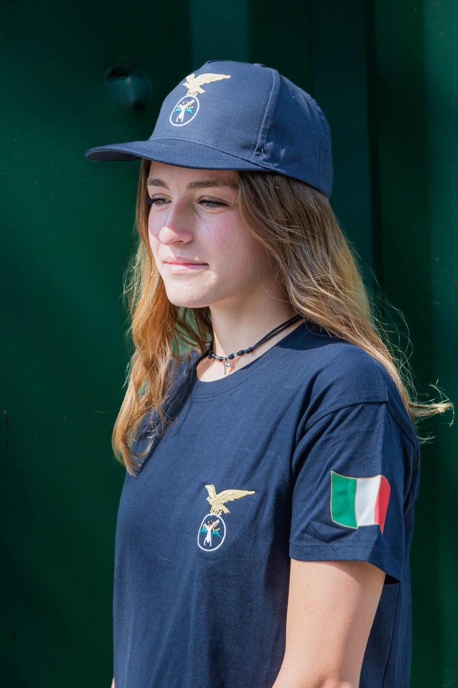 Maglietta blu con aquila ricamata e tricolore sulla manica, indossata da una ragazza
