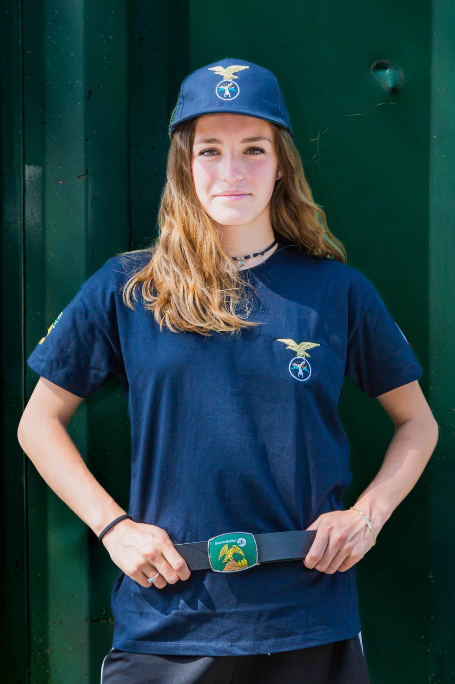 Ragazza con cintura indossata sopra la maglietta blu e cappellino blu