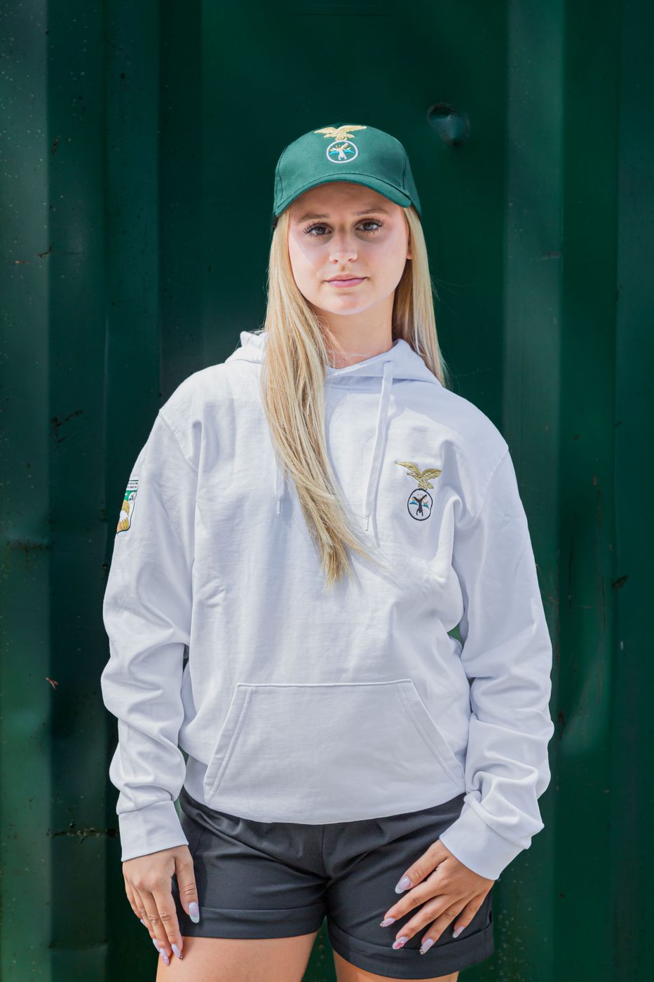Ragazza di fronte con felpa bianca con cappuccio e cappellino verde