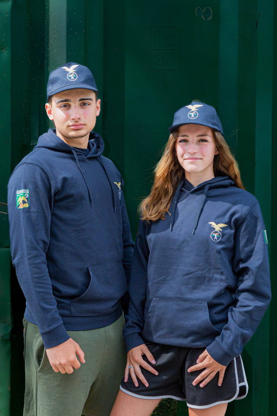Ragazzo e ragazza indossano la felpa blu con cappuccio e il cappellino blu